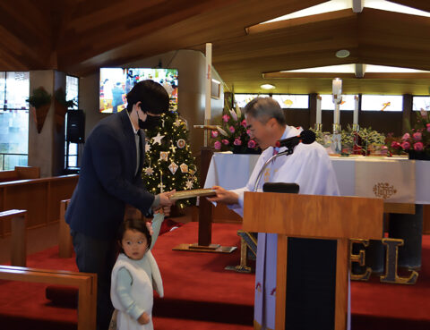 A man receives a certificate from a priest in a church.
