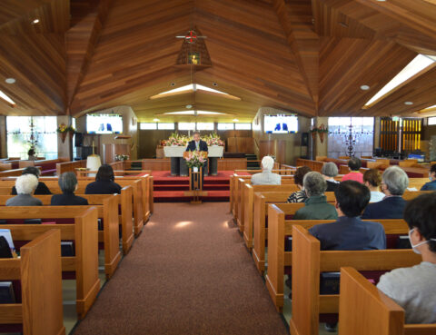 People attending a church service inside a wooden chapel.