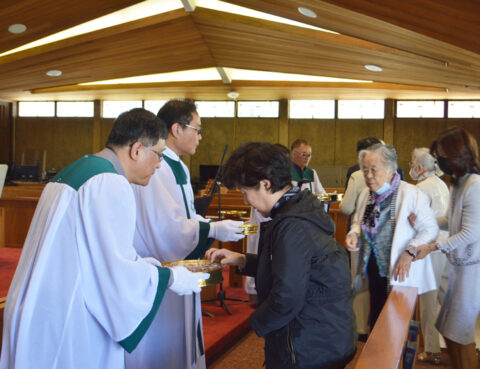 People receiving communion from priests during a church service.