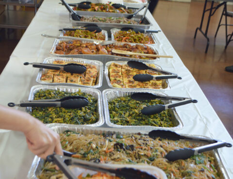 A buffet table filled with various dishes and serving utensils.
