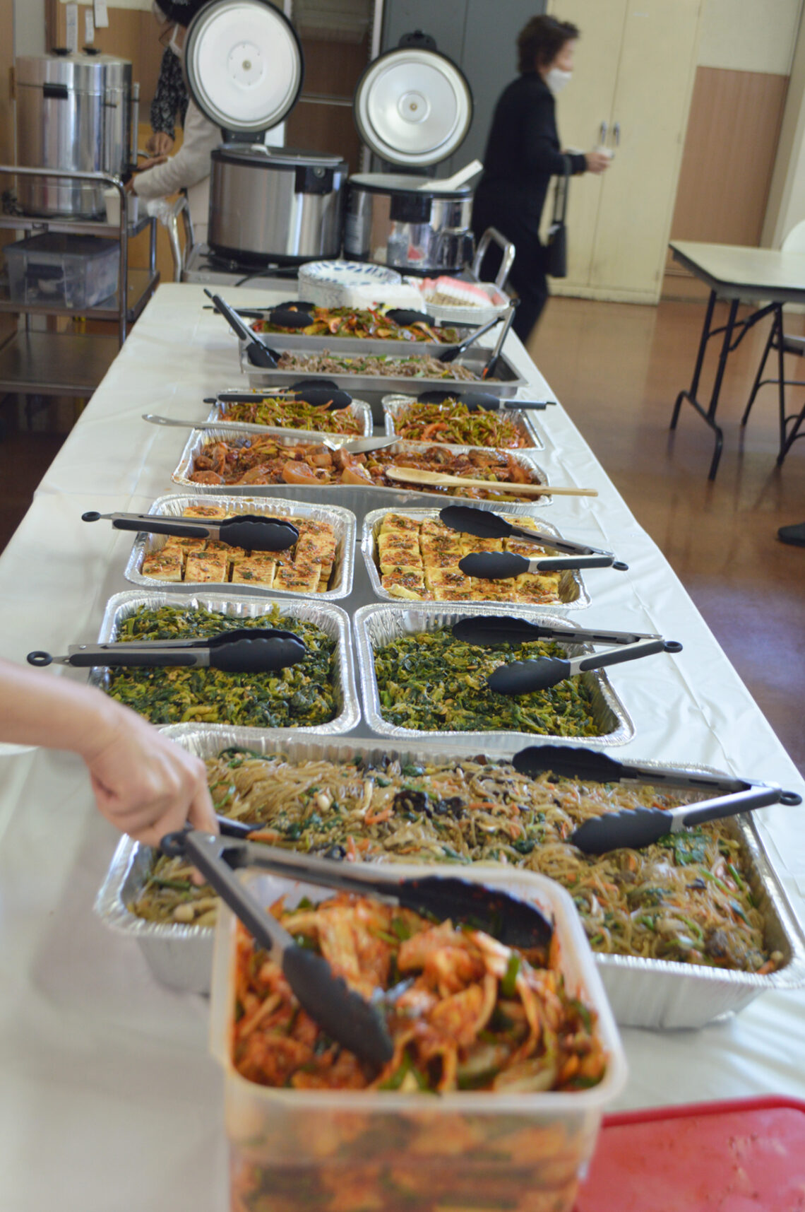 A buffet table with various dishes served in trays.