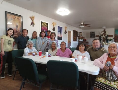 A group of people gathered around a table in a cozy room.
