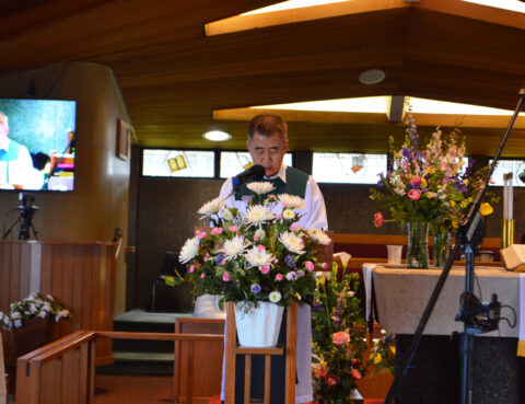Man arranging flowers in a church setting.